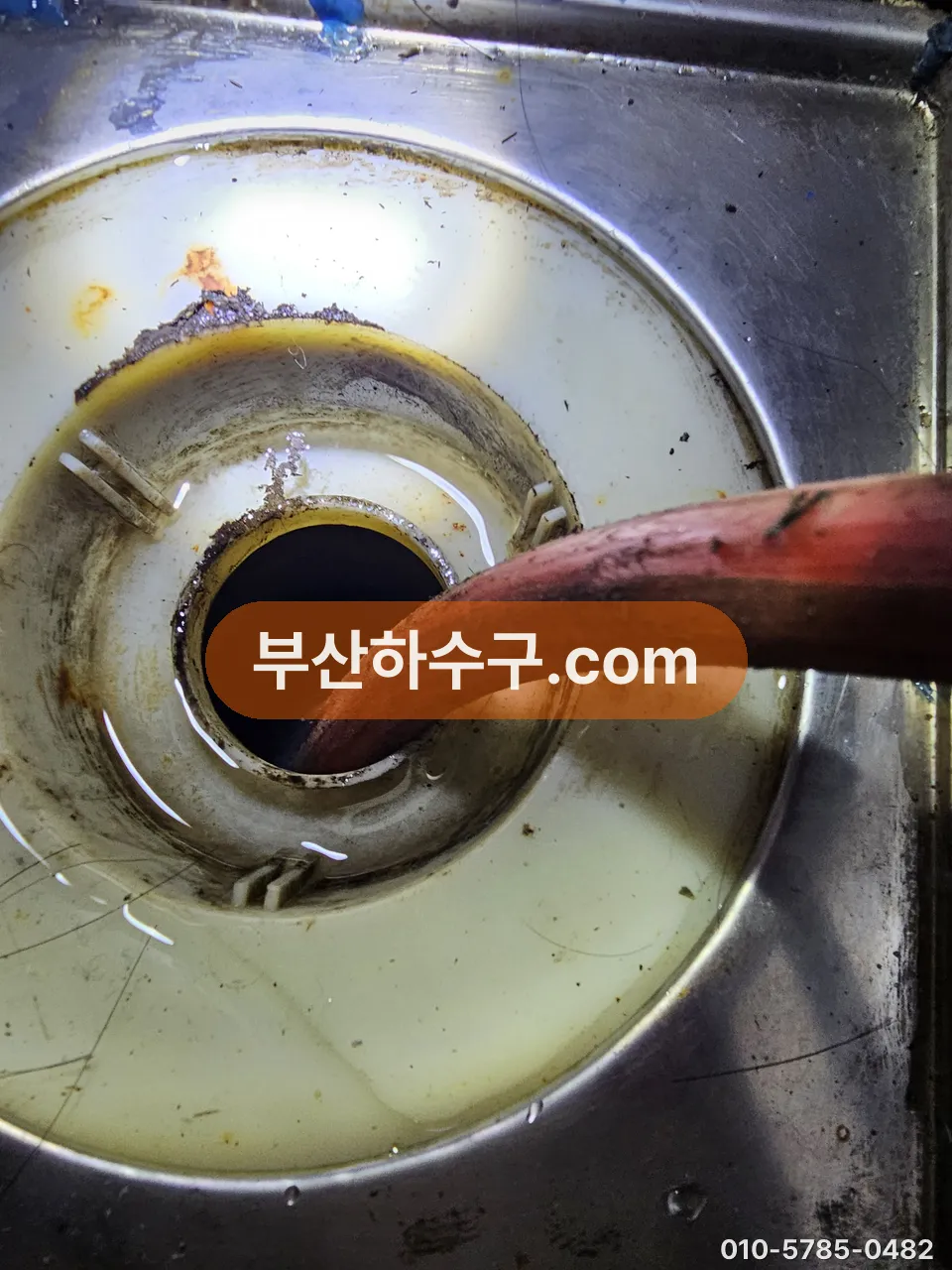 싱크 배수구로 호스를 넣어 라인을 세척하는 작업
