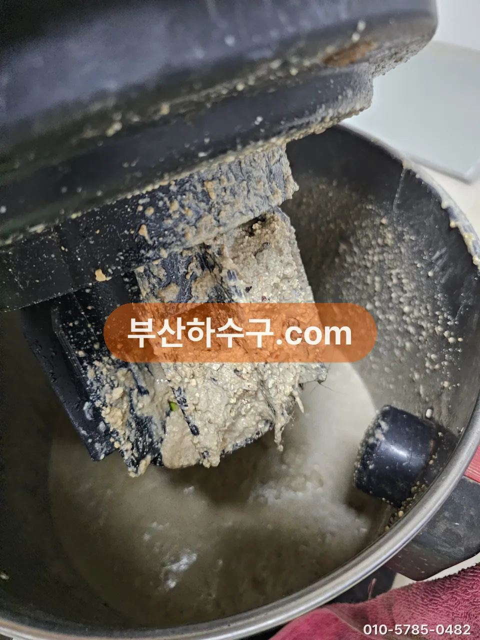 배수 트랩 안쪽에 두껍게 굳어 붙은 기름 슬러지층을 들어내 확인한 모습
