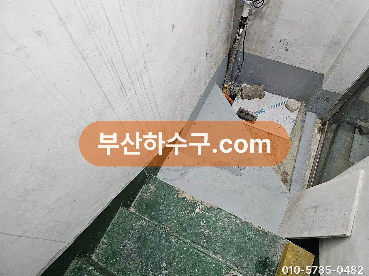 지하로 내려가는 계단 벽에 남은 침수 물 자국, 역류가 올라온 높이를 보여주는 흔적