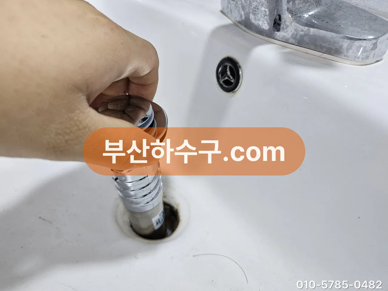 세면대 배수 구멍에 새 팝업 몸체를 끼워 넣는 교체 작업